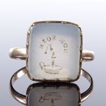 An unmarked yellow metal intaglio carved Bon Soir chalcedony panel seal ring, with chamber stick