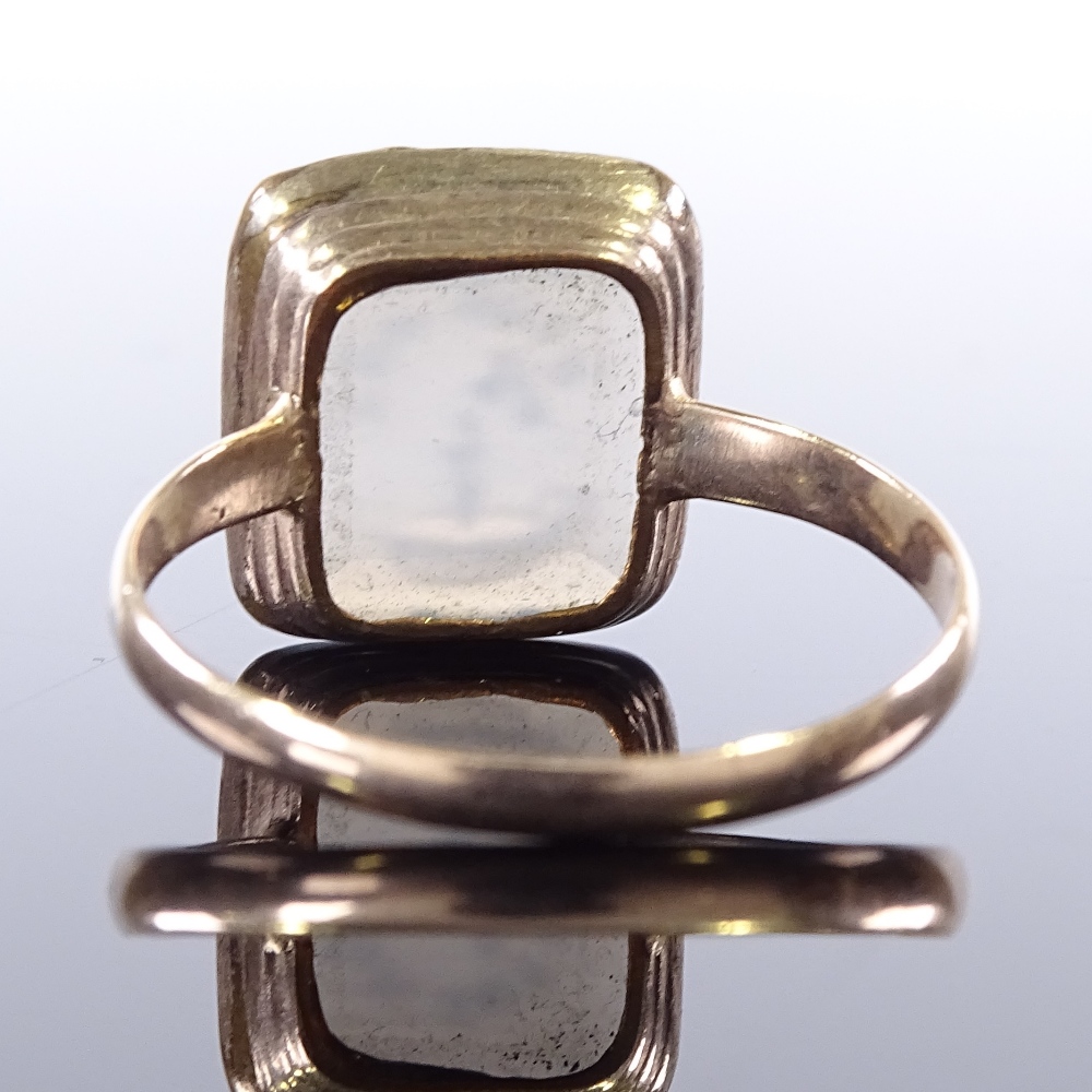 An unmarked yellow metal intaglio carved Bon Soir chalcedony panel seal ring, with chamber stick - Image 2 of 4