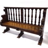 A 19th century carved oak hall settle with spindle-back and lion paw feet, length 158cm