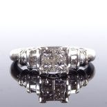 A 14ct white gold diamond cluster ring, set with Princess and tapered baguette-cut diamonds, total