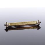 An Art Deco 15ct gold bar brooch, 18ct white gold tips with engine turned decoration, maker's