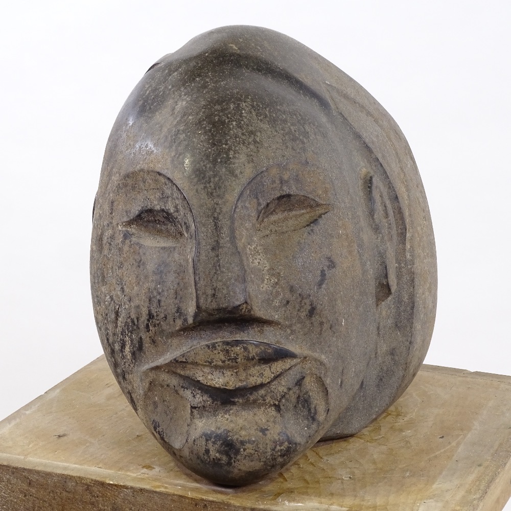 A relief carved basalt rock head sculpture, height 25cm, length 28cm