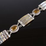 A Scottish unmarked silver banded agate and citrine panel bracelet, engraved floral settings,