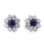 A pair of unmarked white metal sapphire and diamond cluster earrings, total diamond content approx
