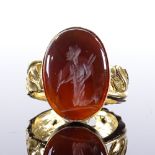 A silver-gilt intaglio carved carnelian seal ring, depicting kneeling man, scrolled and pierced