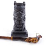 A walking stick with carved wood Native American Indian design handle, and a composition Totem