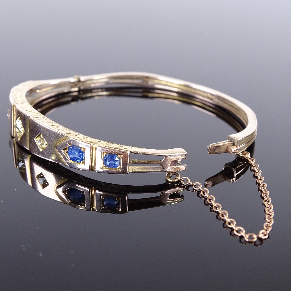 A Victorian unmarked gold sapphire and diamond hinged bangle, floral engraved bridge, total - Image 4 of 4