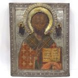 A Russian silver-fronted icon, 18th or 19th century, painted portrait of a saint with Cyrillic