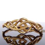 An early 20th century yellow metal hinged bangle, textured inter-woven settings, stamped A18C,