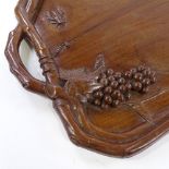 An early 20th century walnut 2-handled tea tray, with heavy relief carved grapevine and insect