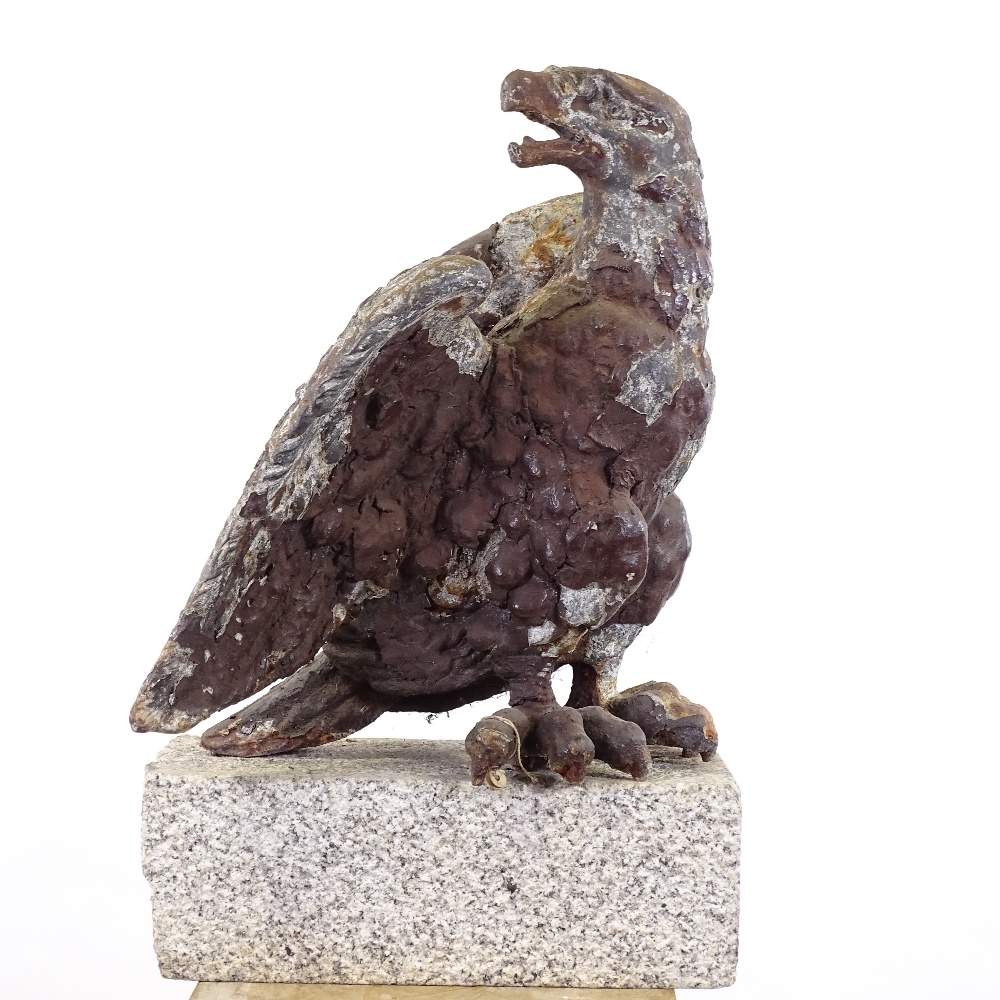 A 19th century cast-iron architectural heraldic eagle, mounted on natural stone base, overall height