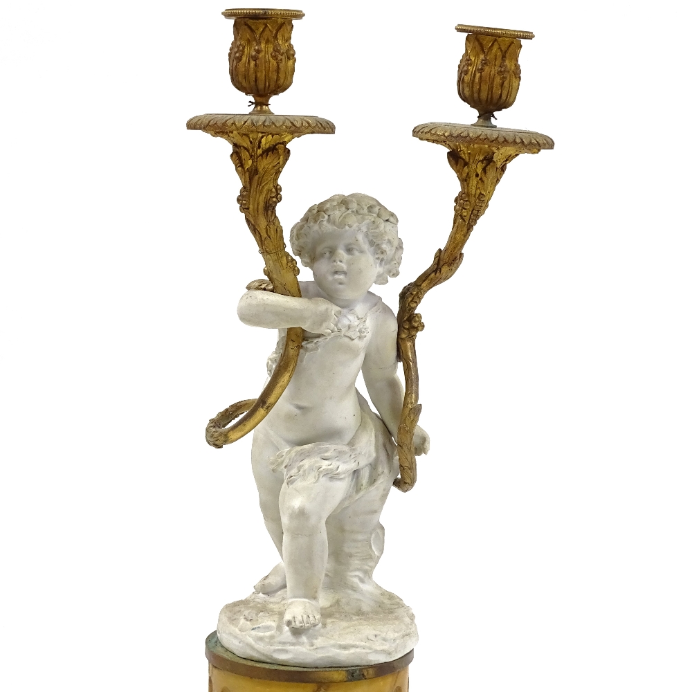 A 19th century bisque porcelain and ormolu-mounted twin-branch candelabrum on fluted yellow marble