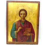A Russian painted and gilded wood icon, 18th or 19th century, depicting a saint with Cyrillic
