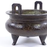 A Chinese patinated bronze 2-handled Ding incense burner, with incised decoration and 6 character