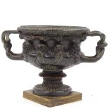 A 19th century Classical design bronze 2-handled urn, decorated with relief cast masks and