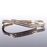 A 9ct gold diamond crossover hinged bangle, total diamond content approx 1ct, band width 5.8mm,
