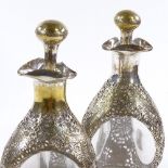 A pair of Chinese dimpled glass decanters with low grade pierced and engraved silver overlay, height