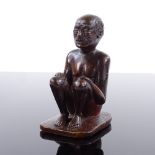 An Indian 19th century wood carving of a seated man, height 9.5cm