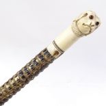 A 19th century shark vertebrae walking stick with carved ivory dog's head handle (missing one eye)