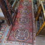 An Iranian red ground wool runner with gull decoration, 280cm x 95cm