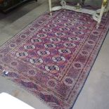 An Antique red ground Tekki rug with symmetrical border and pattern, 190cm x 113cm