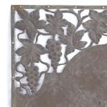 An Art Nouveau copper door pediment, pierced grapevine decoration and planished central panel,