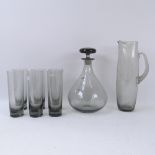 A grey glass decanter, matching tumblers and water jug
