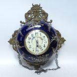 An ornate French brass and ceramic-cased wall hanging clock, with enamel dial and 8-day movement,