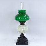 A painted cast-iron oil lamp, with milk glass font, green shade and chimney, overall height 56cm