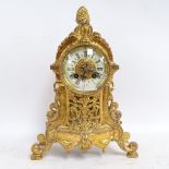 A brass-cased 8-day mantel clock, enamel dial with Roman numeral hour markers, striking on a bell,