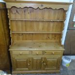 A polished pine 2-section fitted dresser, W138cm, H190cm