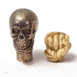 A 19th century carved ivory hand holding snake parasol handle tip, and a silver plated skull walking