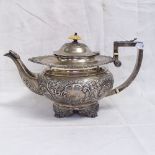 A George IV silver teapot, with cast edge floral relief decorated body on cast acanthus leaf feet