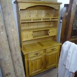 A modern oak 2-section dresser, open shelves above drawers and cupboards, on stile legs, W110cm,