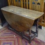 A joined oak oval gateleg table with end frieze drawer, baluster turned legs