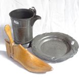 A 19th century pewter court jug, a pewter dish and a cobbler's wooden last