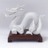 A Chinese porcelain dragon, length 21cm, on wooden stand