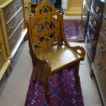 A Victorian golden oak Gothic hall chair, with carved and pierced panelled back