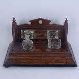 An oak desk stand, with raised bevel-edge mirrored back, 2 inkwells and pen tray, stand length 30cm