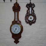 An Edwardian carved oak-cased aneroid wall barometer, and a Black Forest style barometer (2)
