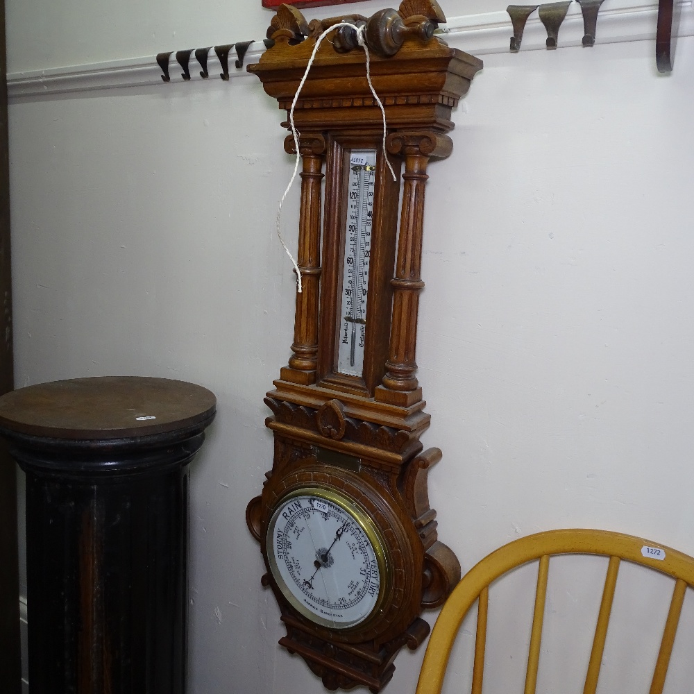 An Edwardian carved oak-cased aneroid wall barometer and thermometer, with brass presentation plaque