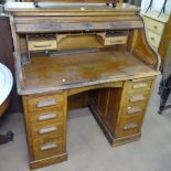 A 1920s oak roll-top twin-pedestal writing desk, W107cm, D69cm, H118cm