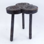 A carved and stained oak clover tripod stool, height 36cm