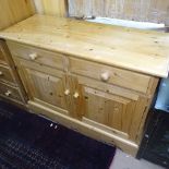 A polished pine dresser base, with 2 frieze drawers and panelled cupboards under, on plinth base,