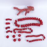 A collection of carved and polished red coral bead necklaces and bracelets, and a piece of rough