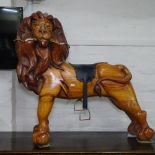 A carved pitched pine child's sit-on lion, W85cm, H80cm