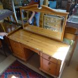 A polished pine knee-hole dressing table, with 7 short fitted drawers on ogee bracket feet, by