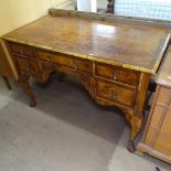 A Georgian style knee-hole desk circa 1900, with quarter veneered top, 5 frieze drawers and carved