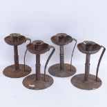 A set of 4 German Arts and Crafts Hugo Berger iron table candlesticks, hammered bases and stems with