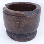 An 18th century turned wood mortar, diameter 23cm, chunk missing and stapled